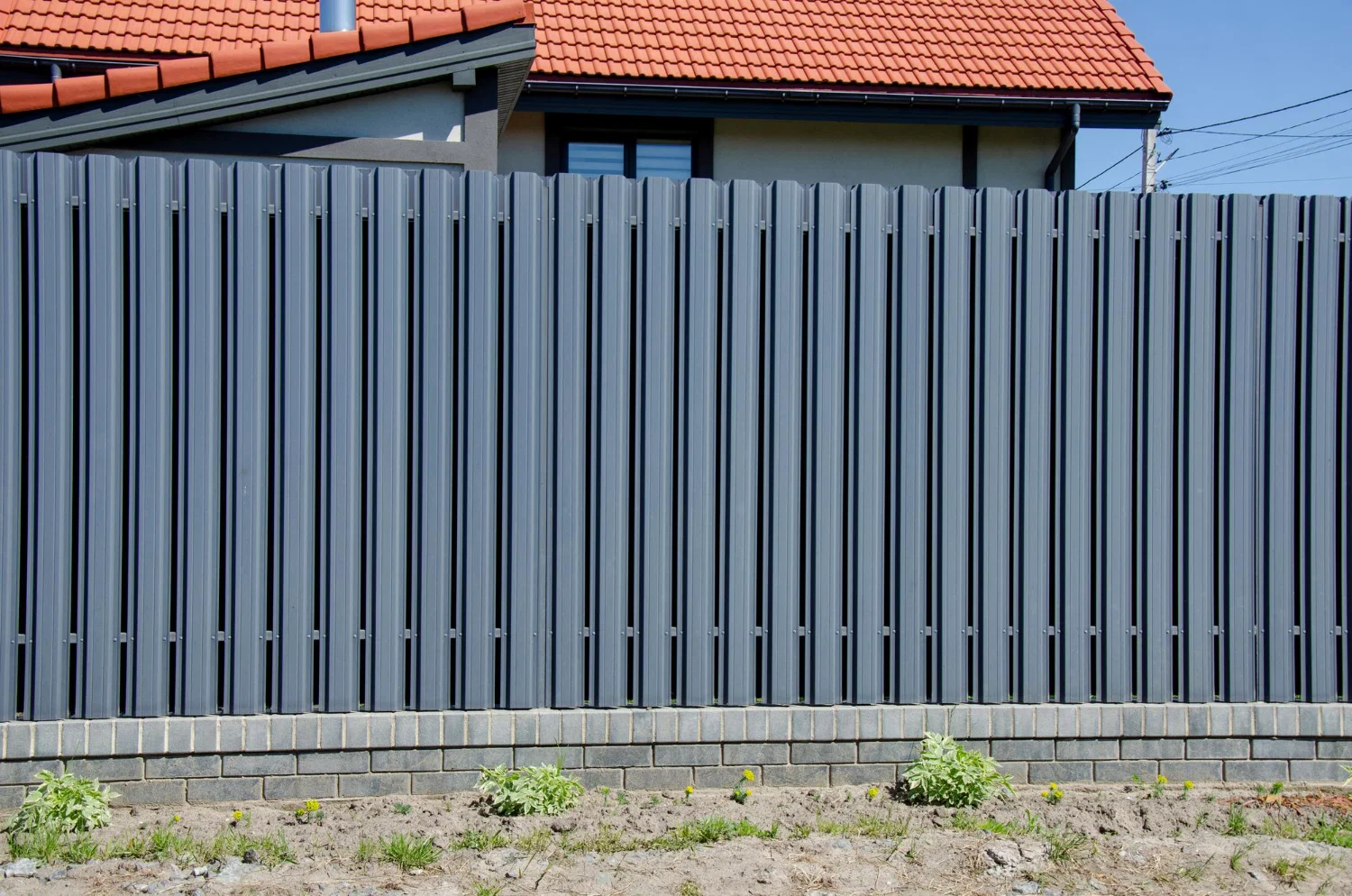 Professional fence installation work being performed by landscaping crew in residential yard